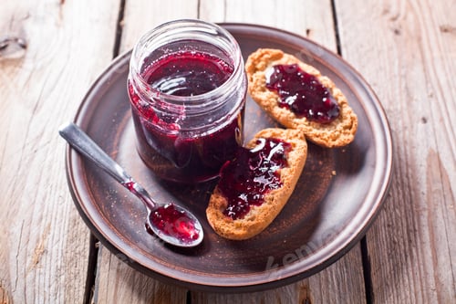 Preview: black currant jam in glass jar and crackers