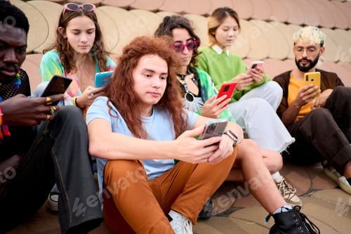 Preview: Side view large multiracial group young friends using cell phones outdoors. LGBT diverse community.