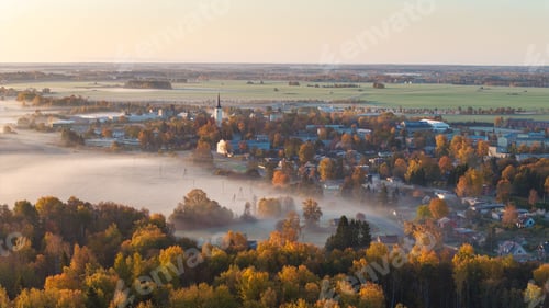 Preview: Scenic view of a foggy autumn rural landscape with a church tower in Haljala, Estonia