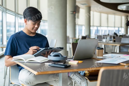 Preview: Young collage student using computer and mobile device studying online.