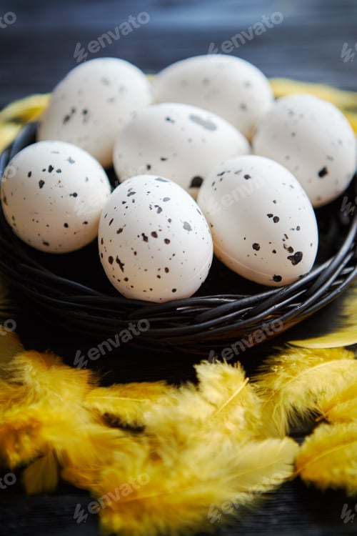 Preview: Whole Chicken eggs in a nest on a black rustic wooden background. Easter symbols
