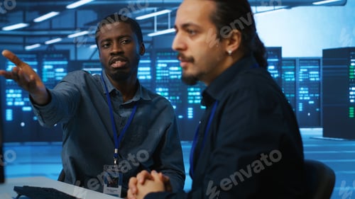 Preview: Joyous admins at PC desk in high tech facility overseeing server clusters