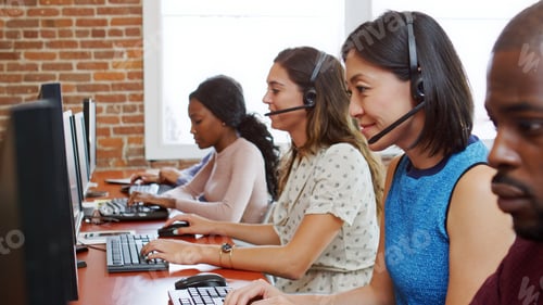 Preview: Multi-Cultural Business Team Wearing Headsets Working In Busy Customer Service Department
