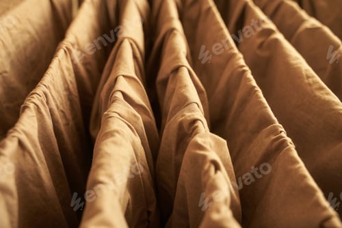 Preview: Close up of brown fabric folds in vertical arrangement displaying textured