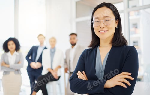 Preview: Portrait of a confident young asian businesswoman wearing glasses and standing with her arms crosse