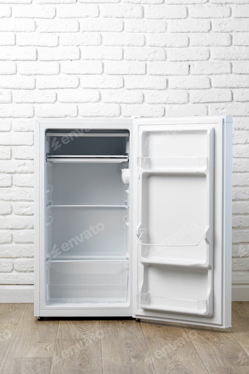 Preview: Empty White Refrigerator With Open Door In Front Of White Brick Wall