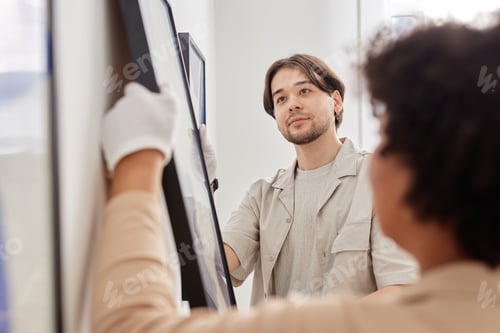 Preview: Happy Man as Art Gallery Worker Hanging Art Painting in Museum