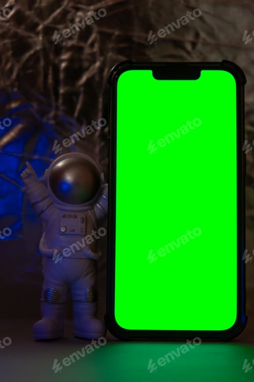 Preview: Plastic toy figure astronaut with mobile phone chroma key green screen for your advertisement Copy