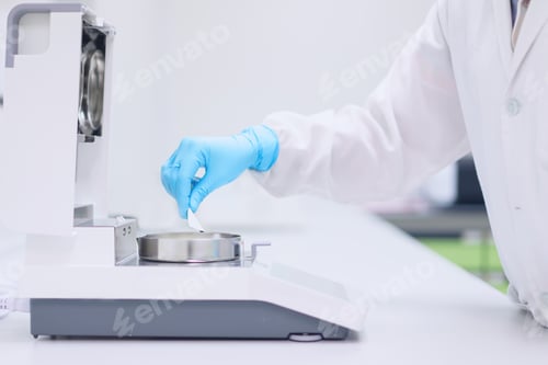 Preview: Unidentified operator is testing moisture content in sample with automatic moisture balance.an