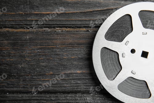 Preview: Movie reel on wooden background, top view with space for text. Cinema production