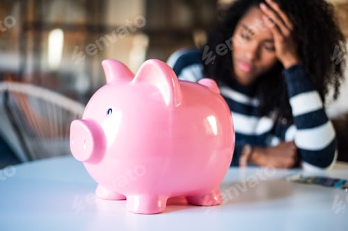 Preview: Sad frustrated black woman with piggy bank