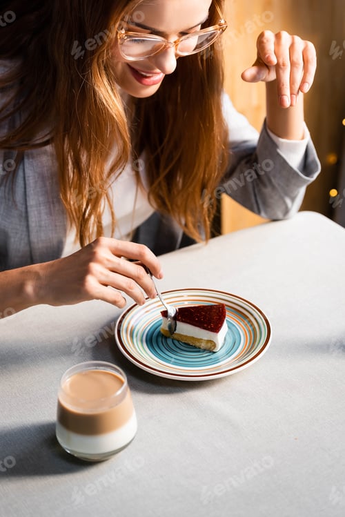 Preview: happy beautiful woman eating cake with coffee in cafe
