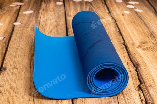Preview: Closeup shot of a blue yoga mat on a wooden surface