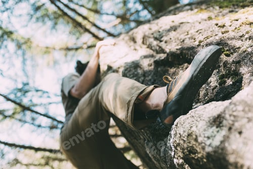 Preview: Low angle view of male boulderer climbing boulder, Lombardy, Italy
