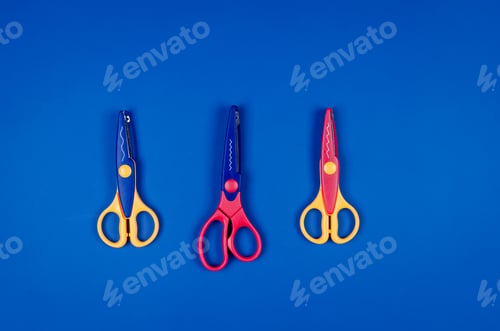Preview: different scissors for children's creativity on blue paper background