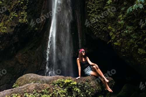Preview: Beautiful girl at a waterfall on the island of Bali Indonesia. Sexy woman at the waterfall