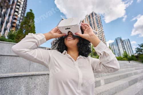 Preview: Happy multiracial woman standing outdoors wearing virtual reality glasses