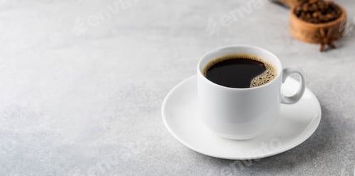 Preview: Black coffee in a white mug on a saucer on a grey table. Copy space.