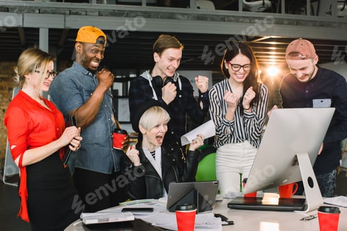 Preview: Beautiful multiethnical young business people in casual clothes are using a laptop and tablets