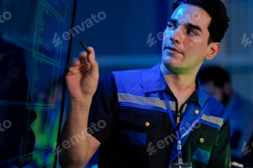 Preview: Caucasian male engineer in a uniform smiles while using a stylus on a screen