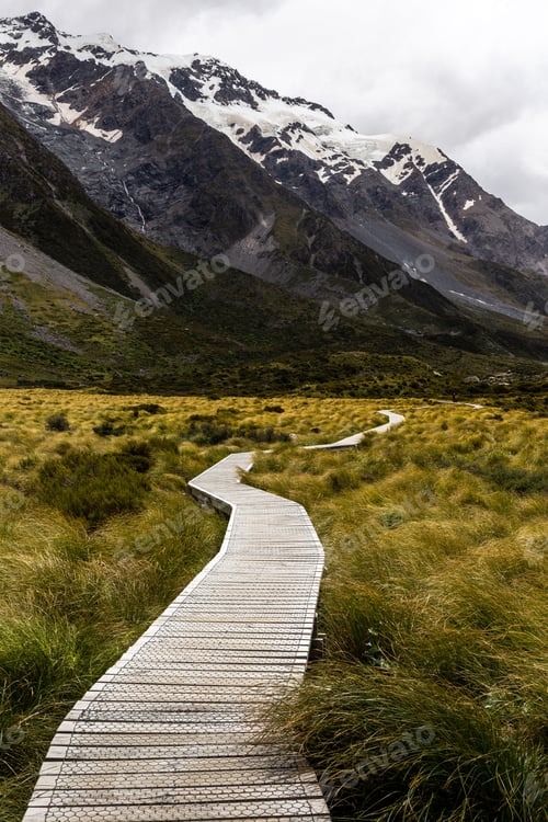 Preview: a boardwalk leading into a mountain landscape, with snow - capped mountains in the background