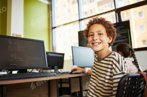 Preview: Portrait of Caucasian Boy Smiling While Using Computer in Classroom Setting