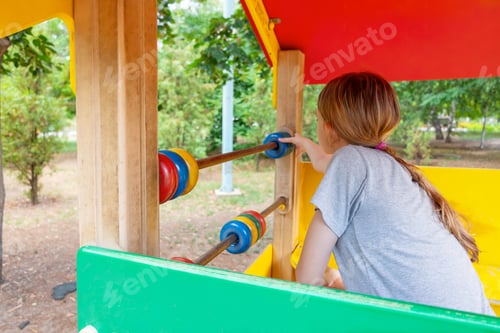 Preview: Girl playing with abacus on colorful playground structure