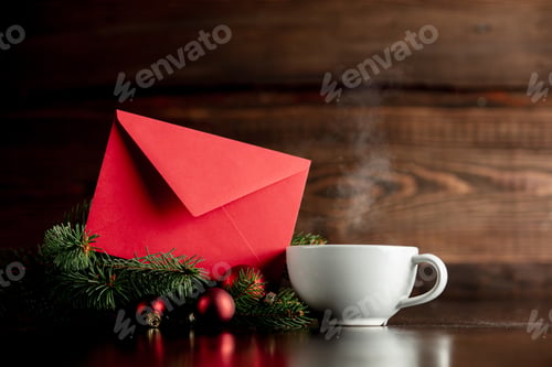 Preview: Cup of coffee and red envelope on wooden table