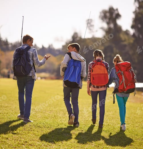 Preview: Shot of a group of children wearing backpacks walking together in nature