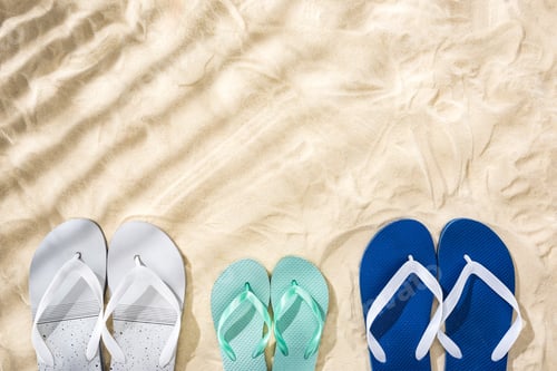 Preview: top view of white, turquoise and white blue flip flops on sand with shadows and copy space