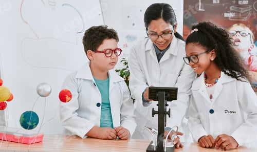Preview: Shot of a young science teacher using a microscope with her pupils in science class at school