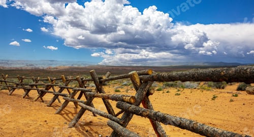 Preview: Log fence in a desert land, blue sky with clouds. Sunny spring day in American countryside, USA