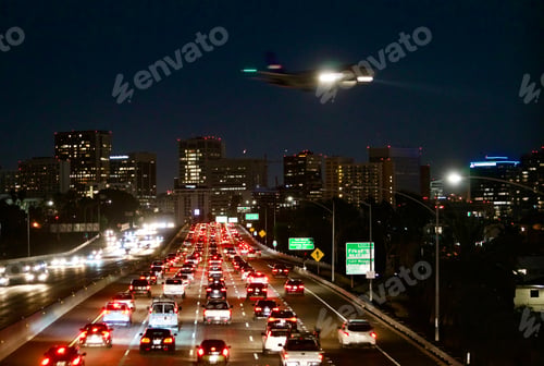 Preview: Plane flies over traffic and city lights at night in San Diego California