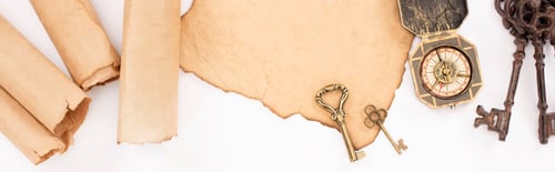 Preview: top view of vintage keys and compass on aged paper isolated on white, panoramic shot