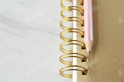 Preview: Gold notebook and pink pencil