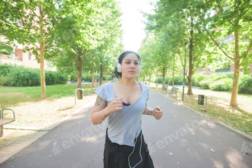 Preview: sportive young mixed race curly black hair woman running in a park