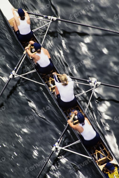 Preview: Overhead view of a female rowing crew in their racing shell, rowing boat.