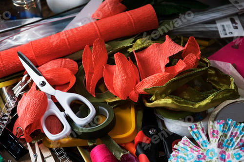 Preview: High angle close up of pair of scissors and fabric cuts in various colours.