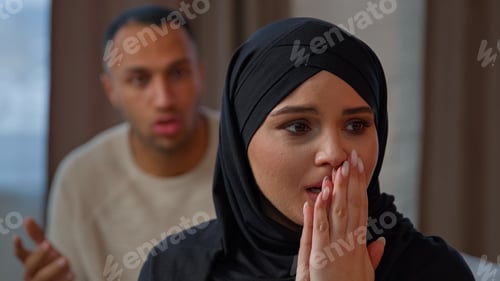 Preview: Couple quarrel sad crying muslim woman wife sit on couch screaming husband accusing wife. Breakup