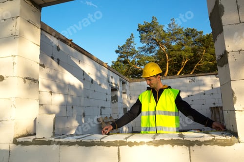 Preview: Construction worker at construction site measures the length of the window opening and the wall