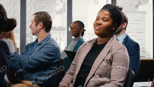 Preview: African american woman listens to business forum panel discussion