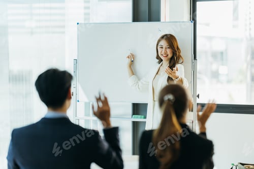 Preview: Group of business people discussing and looking at whiteboard in the office