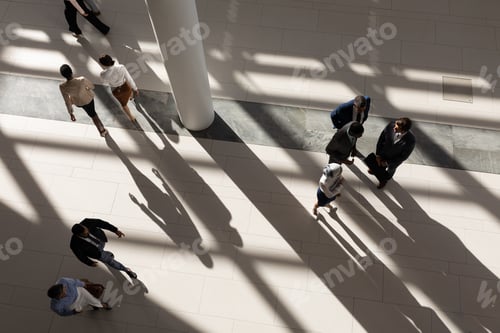 Preview: High angle view of multi-ethnic business executives standing in lobby at office