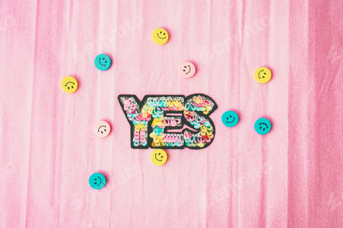 Preview: Word "yes" make with colorful sequins and surrounded by smiley faces
