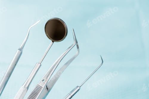 Preview: close up of dental mirror near metallic medical instruments