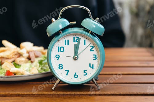 Preview: Close-up, alarm clock on a blurred food background.