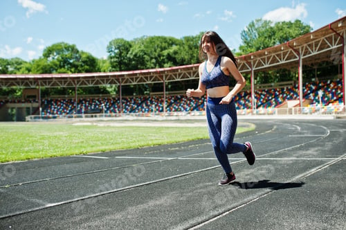 Preview: Portrait of a strong fit girl in sportswear running in the stadium.