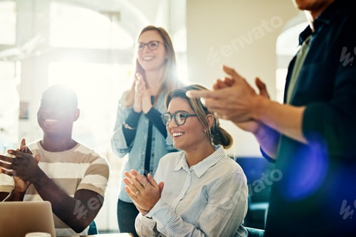 Preview: Smiling group of diverse coworkers clapping during an office presentation