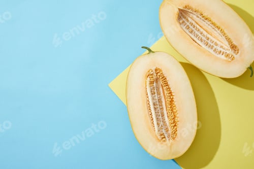 Preview: top view of halved ripe melon on blue and yellow background