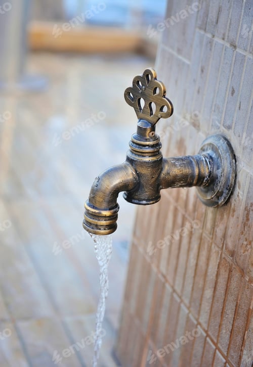 Preview: The bronze tap with flowing water. Vintage old faucet. Close-up.